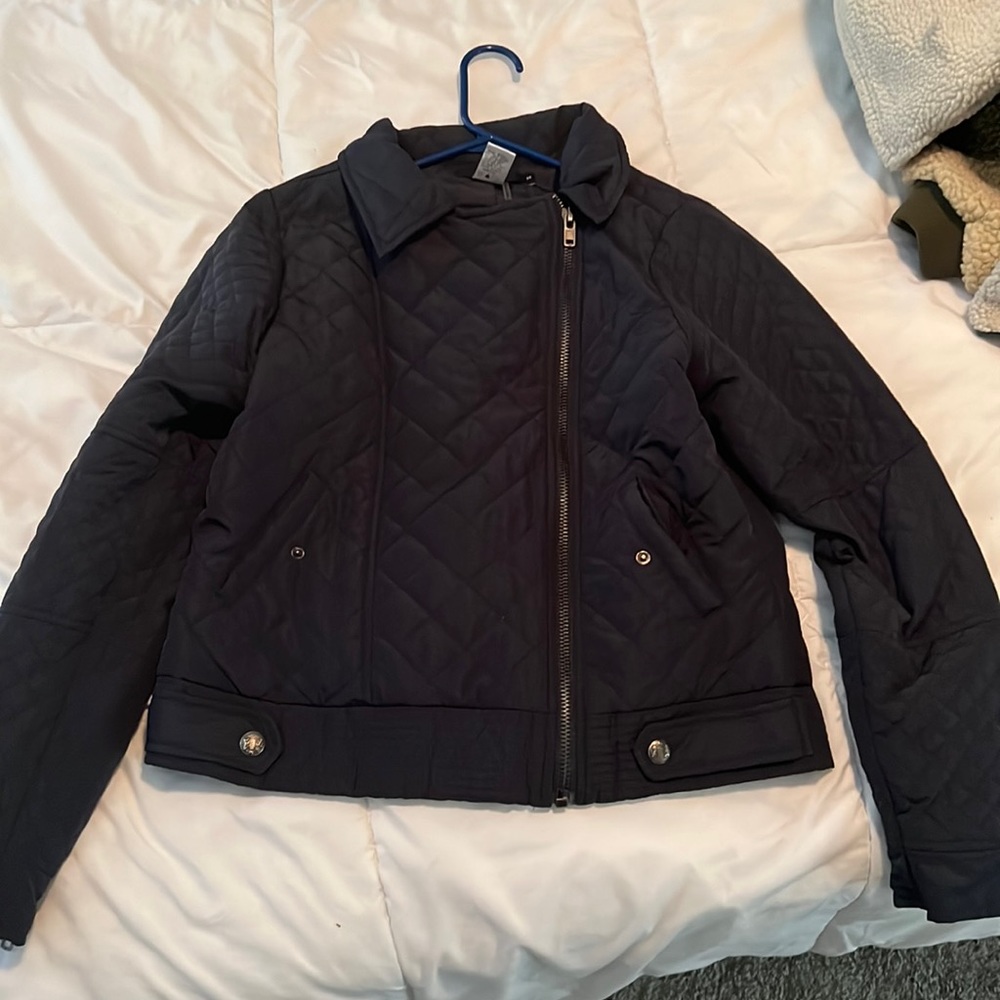 Medium, dark blue, angled zipper, high collared jacket.